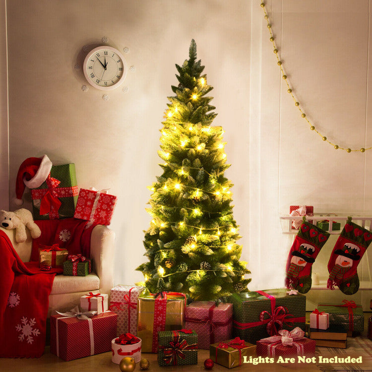 Decorated Christmas tree with lights, presents, and stockings in a living room.