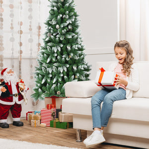 Child opening a gift in a living room with a Christmas tree and presents.