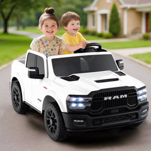 Two children playing in a toy RAM truck on a driveway.