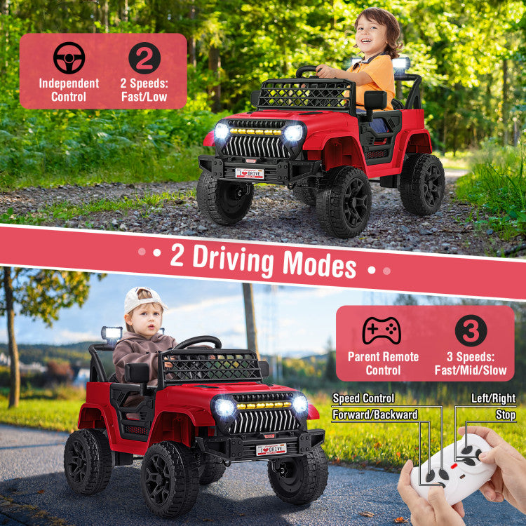 Red toy jeep with two children, one driving and one sitting, on a road and grassy area.