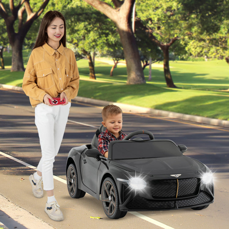 Woman and child with a toy car on a sidewalk in a park