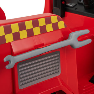 Close-up of a red toy fire truck interior or side panel with a gray toy wrench resting across it, plus a yellow-and-red checkered stripe on the seat area.