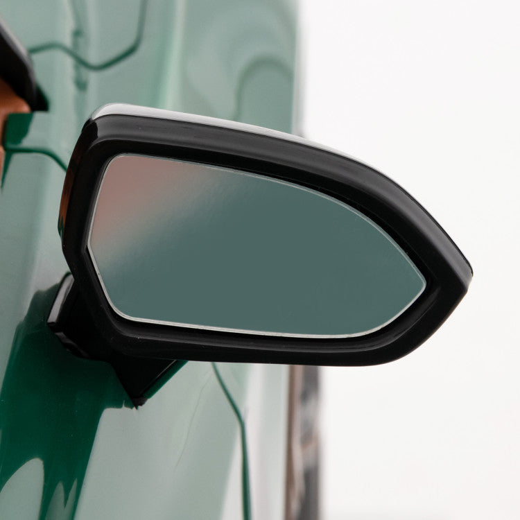 Car side mirror on a green vehicle with a blurred background