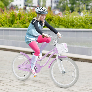 Child riding a pink bicycle with a helmet on a paved path.