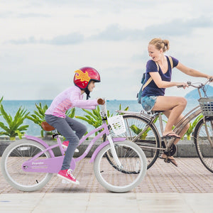Woman and child riding bicycles by a waterfront with greenery.