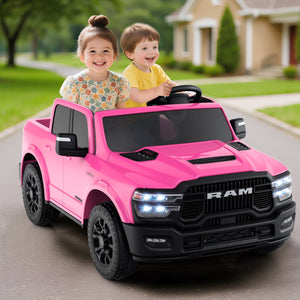 Two children in a pink toy truck with a house and greenery in the background