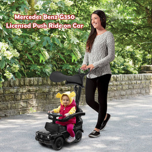 Woman pushing a child in a Mercedes-Benz G350 licensed push ride-on car outdoors.