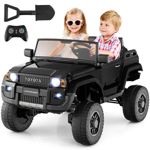 Toy black SUV with children inside, remote control, and shovel on a white background