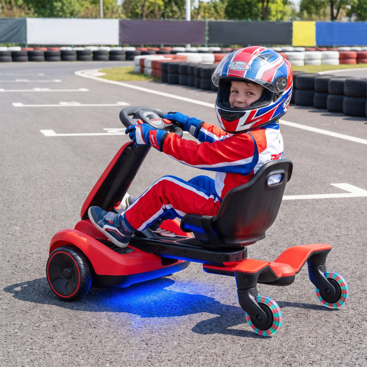 A child wearing a red, white, and blue racing suit and a matching helmet is sitting on a red and black electric go-kart on an asphalt track. The go-kart has blue LED underglow and three wheels.