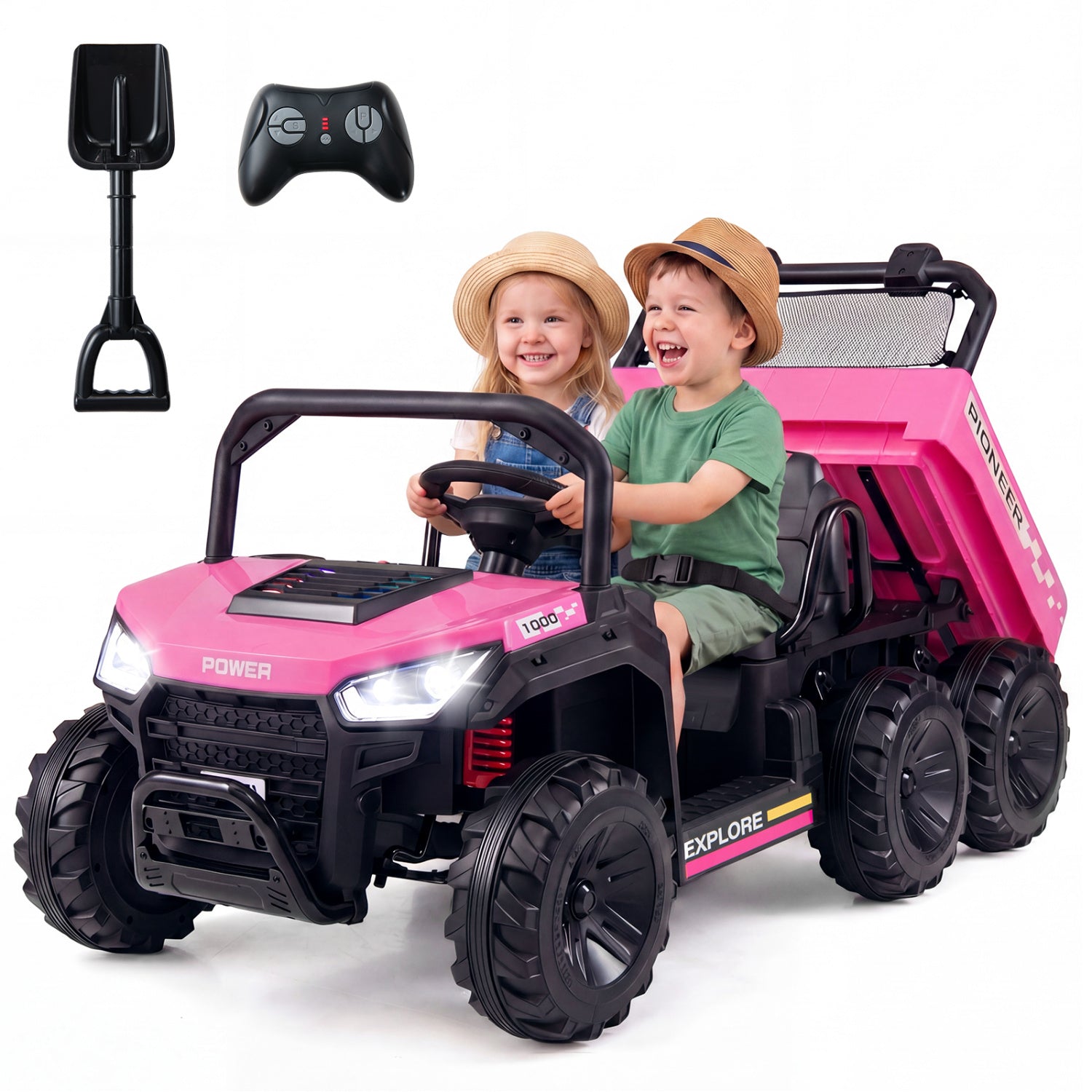 Pink and black toy dump truck with two children inside, a shovel, and remote control on a white background.
