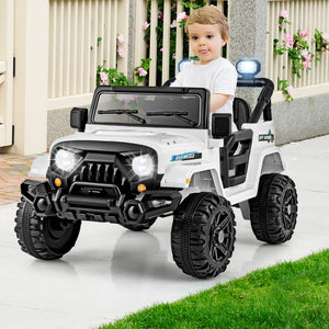 Child sitting in a toy jeep with lights on a patio