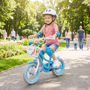 Child riding a bicycle with a helmet and safety pads in a park setting.