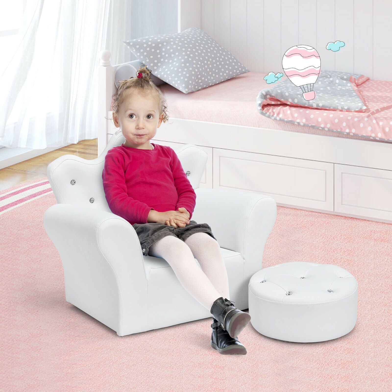 Child sitting on a white chair in a bedroom with pink carpet and white walls.