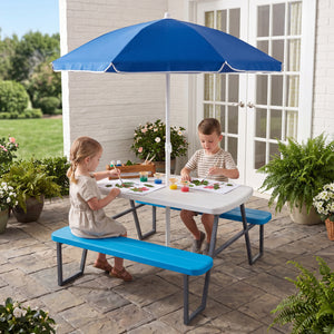 Children sitting at a blue and white picnic table with an umbrella on a patio.