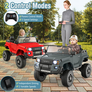 Two toy cars, one red and one gray, with a woman and two children playing outdoors.