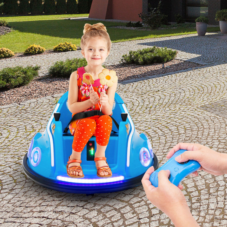 Child sitting in a blue toy car with glowing wheels, outdoors on a stone path.