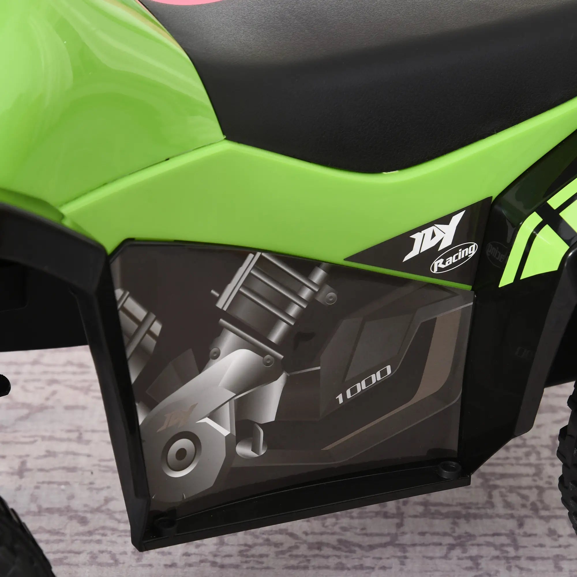 Close-up of a green and black motorcycle with a visible brand logo on a textured surface.