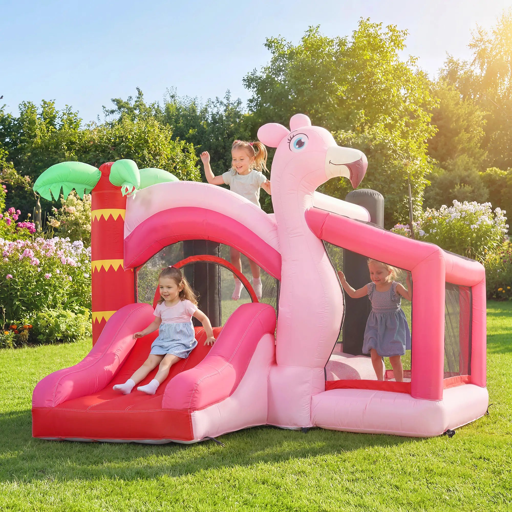 Pink inflatable flamingo play structure with slide and children playing in a garden.