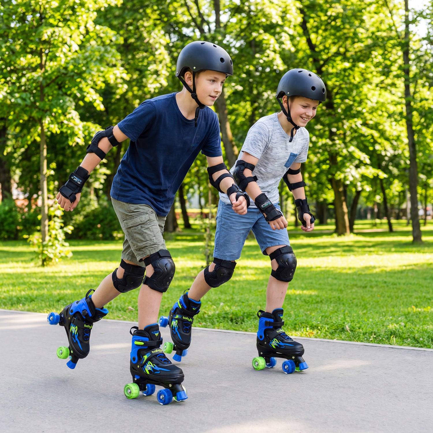 Two children rollerblading in a park with trees and grass in the background.
