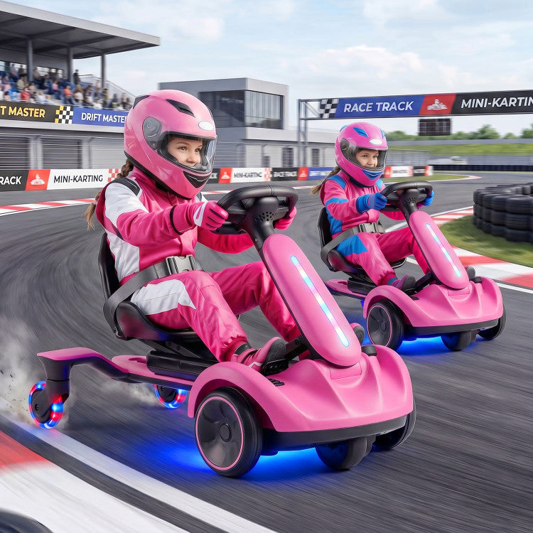 Two children in pink racing cars on a race track with helmets.