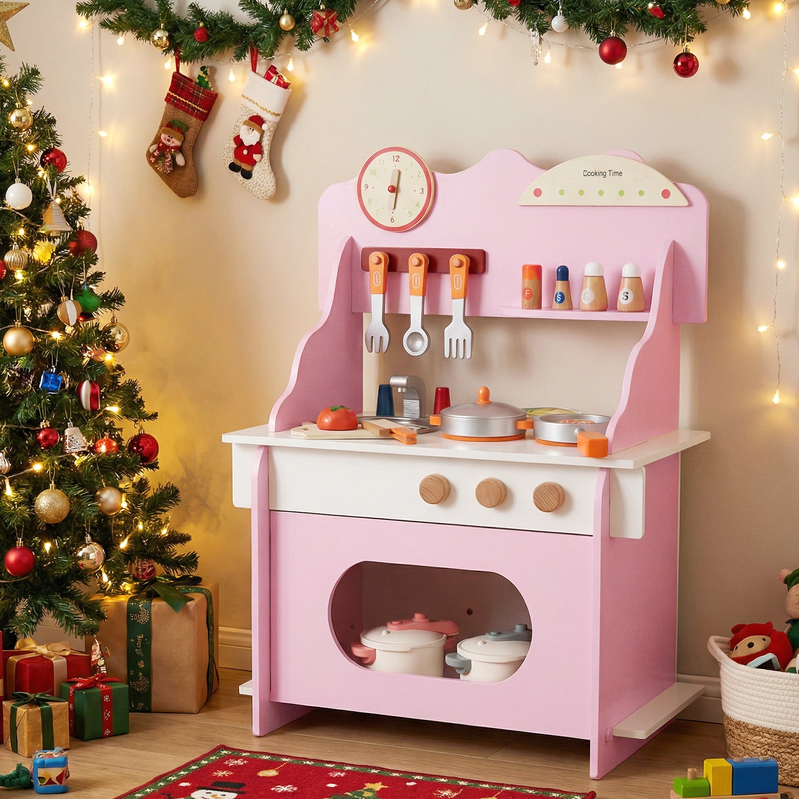 Pink toy kitchen set with Christmas decorations in a room.