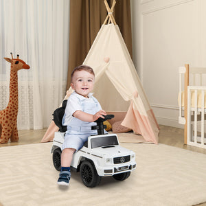 Child playing with a toy car in a room with a teepee and stuffed giraffe.