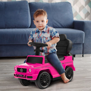 Child playing with a pink toy car in a living room