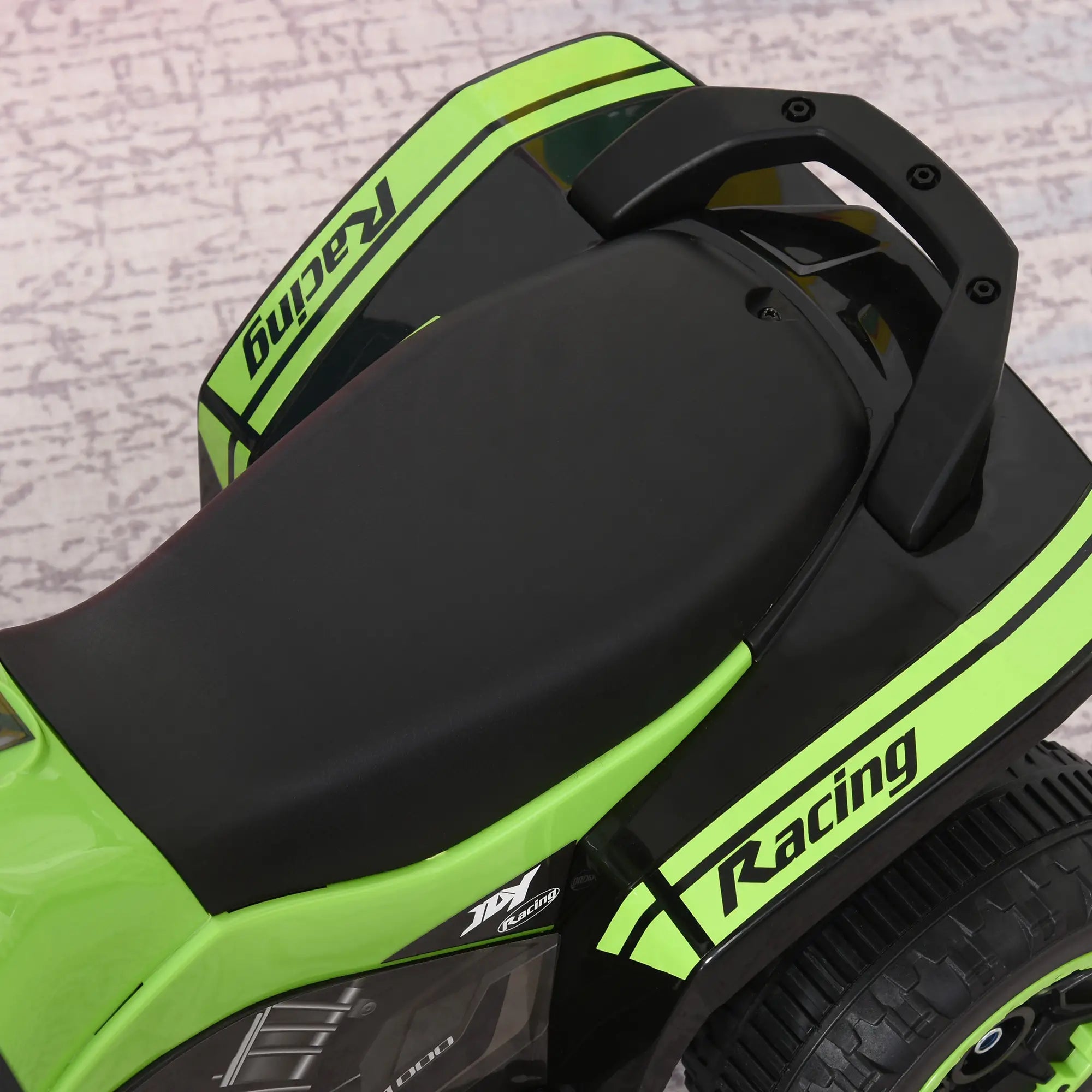 Close-up of a green and black scooter with 'Racing' branding on a textured background