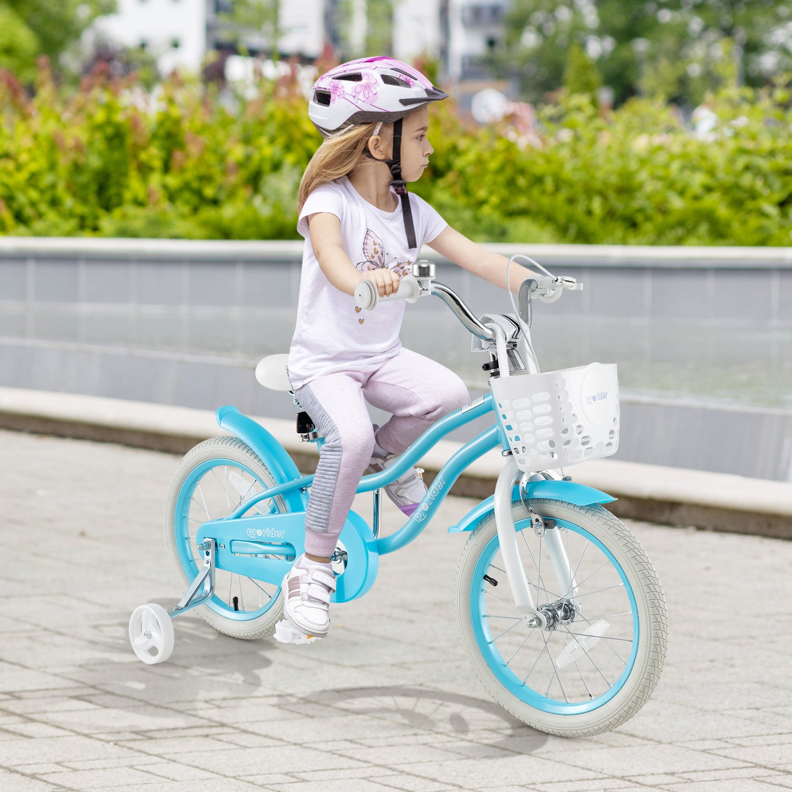 Child riding a blue bicycle with training wheels on a paved path.