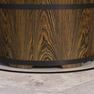 Wooden barrel with a black band on a light gray surface
