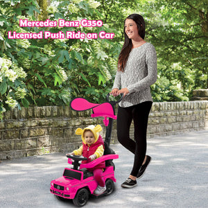 A woman pushes a bright pink Mercedes-Benz G350 licensed push ride-on car with a child seated inside, outdoors on a paved path with trees and a stone wall in the background. Pink text at the top reads 'Mercedes-Benz G350 Licensed Push Ride on Car'.