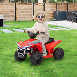 Child riding a red toy ATV in a backyard