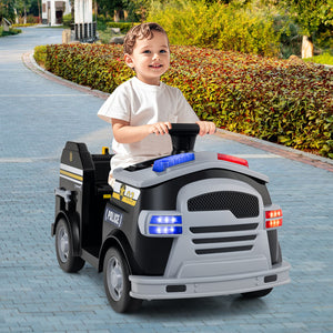 Child playing with a toy police car on a paved path.