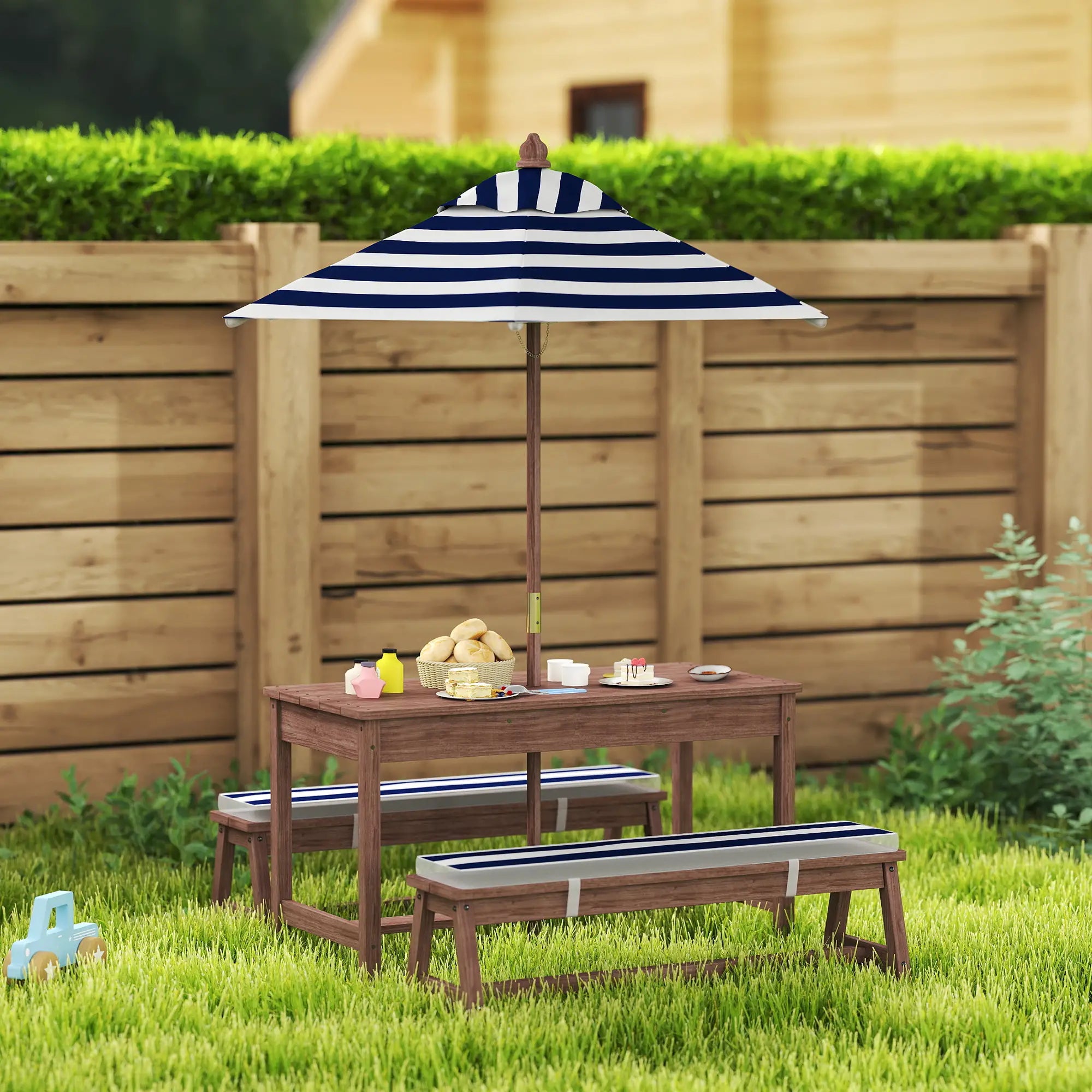 Outdoor furniture set with striped umbrella on a grassy area