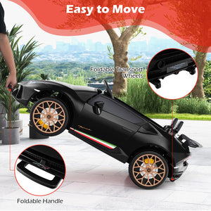 Black toy car with foldable handle and transport wheels on a wooden floor with outdoor scenery.
