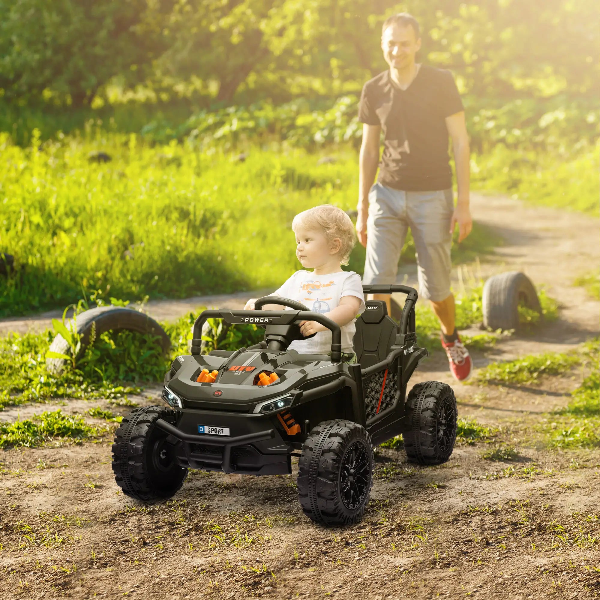 Child in a toy off-road vehicle with an adult in a natural setting