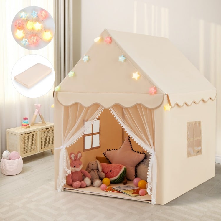 Children's play tent with toys inside, surrounded by fairy lights in a room.