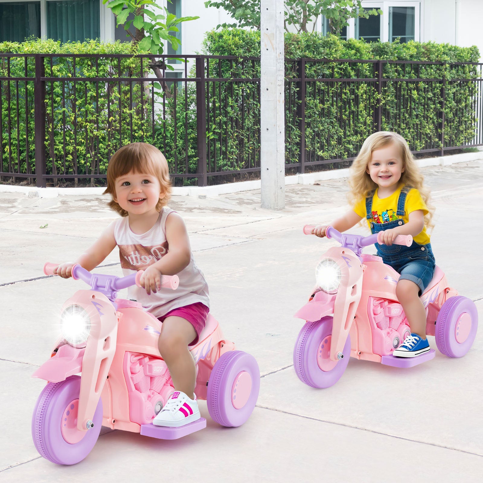 Two children riding pink tricycles on a patio