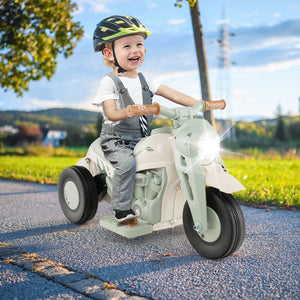 Child riding a toy motorcycle outdoors on a sunny day