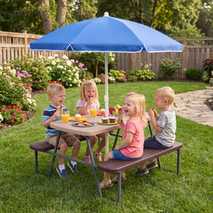 Children sitting at a picnic table with a blue umbrella in a garden setting