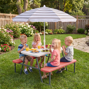 Children sitting at a picnic table with a striped umbrella in a garden setting