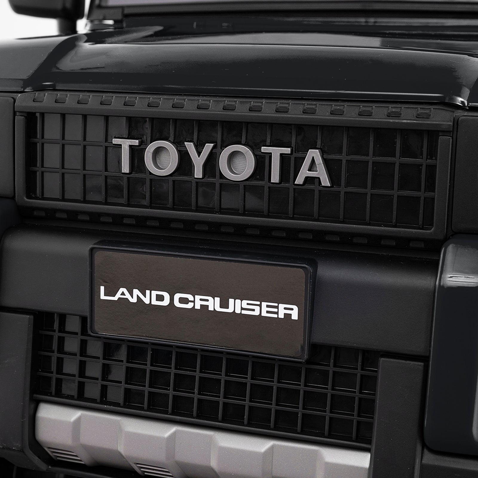Close-up of Toyota Land Cruiser grille with brand logo.