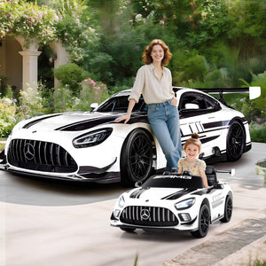 Woman and child with a large and small Mercedes-Benz car model outdoors.