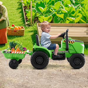Child playing with a green toy tractor and trailer in a garden setting