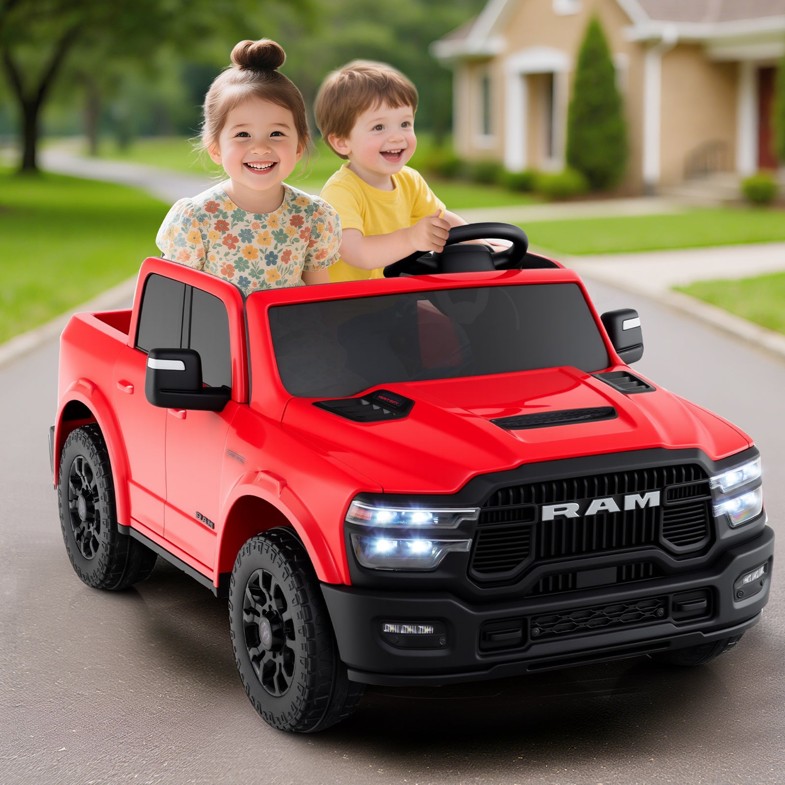 Two children in a red toy truck on a driveway