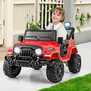 Child sitting in a red toy jeep with a white fence and flowers in the background