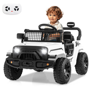 Child sitting in a toy off-road vehicle with a remote control on a white background