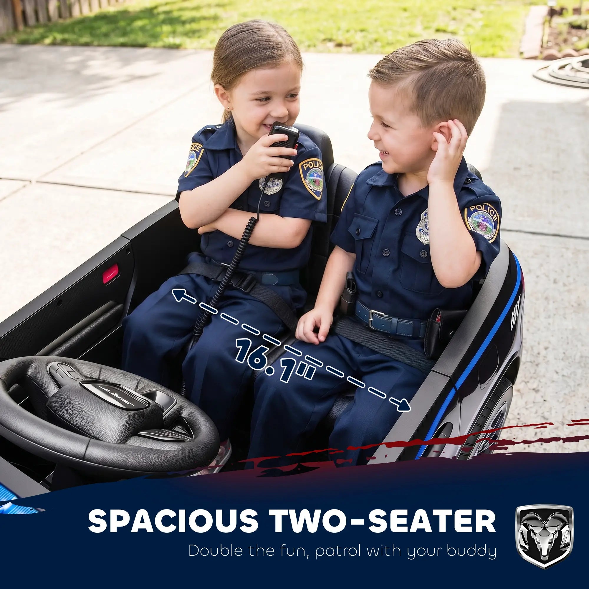 Two children wearing navy blue police uniforms sitting in a black ride-on toy car outdoors. The image includes a text banner at the bottom that reads 'SPACIOUS TWO-SEATER' and shows a Ram logo.