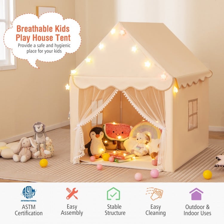 Children's playhouse tent with toys inside, surrounded by soft toys on a carpeted floor.