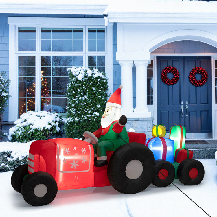 Inflatable Santa Claus on a red tractor with Christmas lights in front of a house.